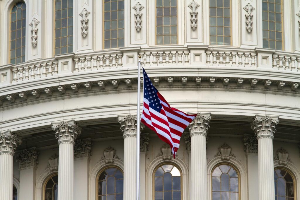 Flag of America Waving Near White Concrete Building