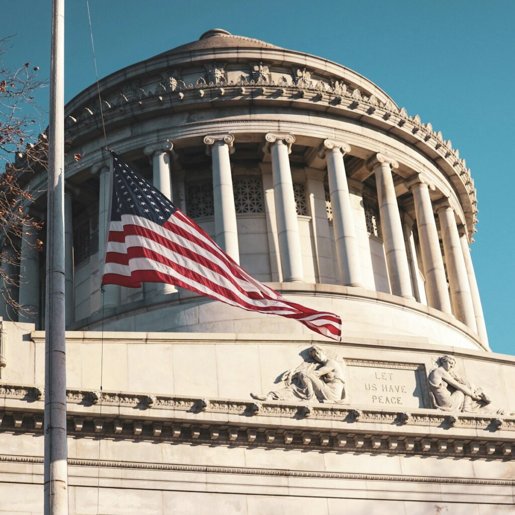 us a flag on white concrete building during daytime