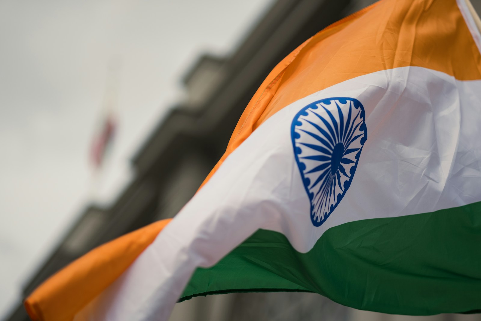 the indian flag is flying in front of a building