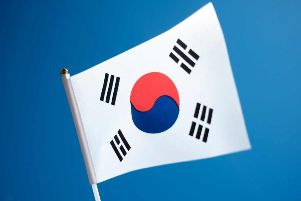 a korean flag flying in the wind with a blue sky in the background