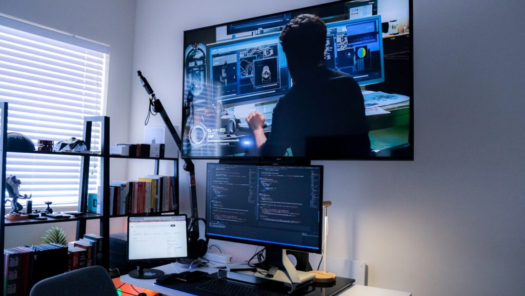 a person sitting at a desk with a computer and a microphone