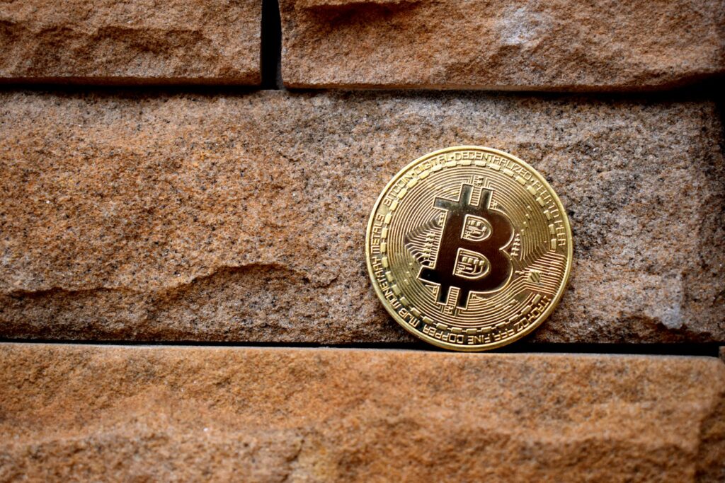 gold round coin on brown brick wall