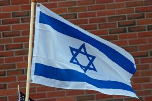 A flag flying in front of a brick building