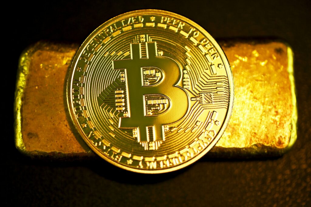 a bitcoin sitting on top of a gold bar