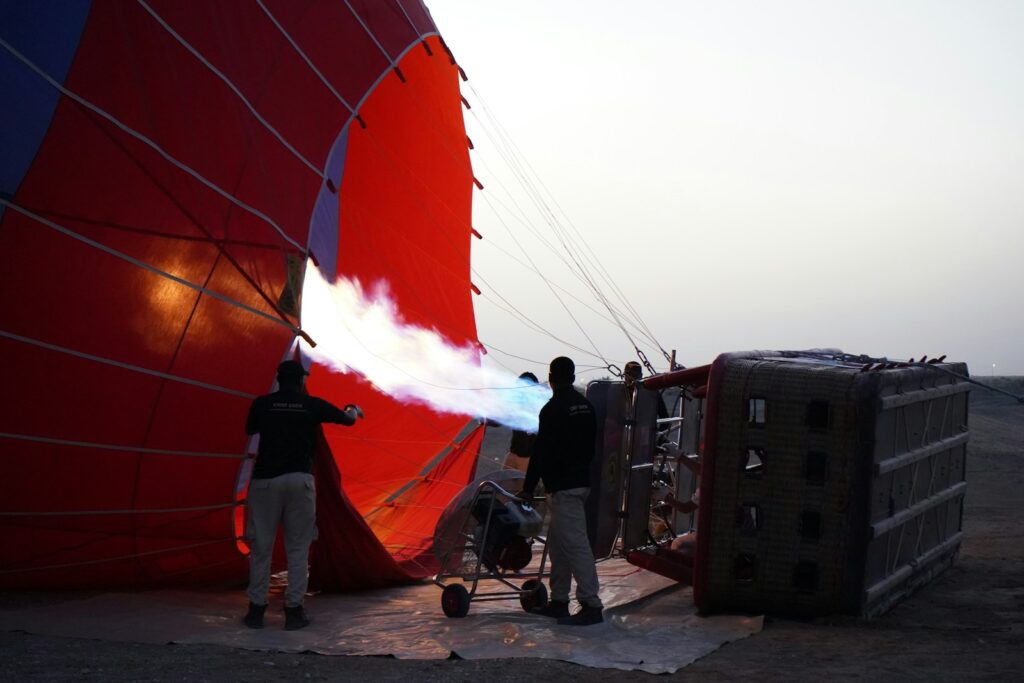 a group of people standing around a hot air balloon