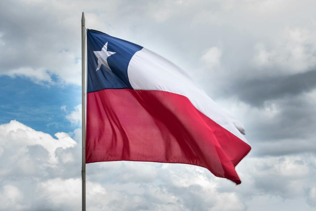 Chilean flag waving against a cloudy sky, symbolizing national pride and unity.