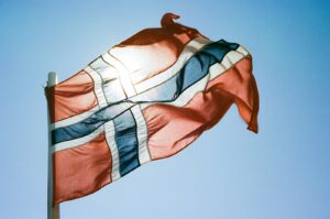 a flag flying in the wind with a blue sky in the background