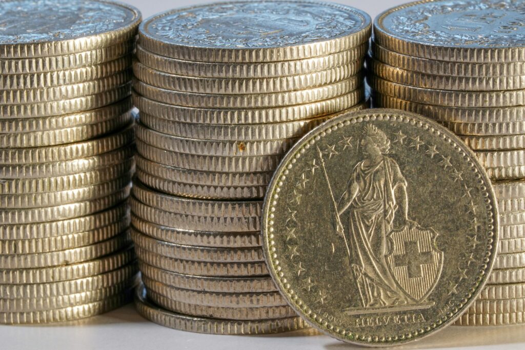 Stacks of gold coins with one coin in front.