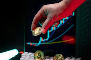 Hand holding ethereum with crypto graphs in background.