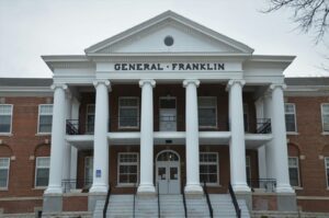 the front of a brick building with columns