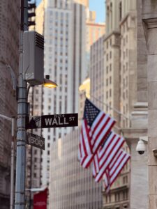 Wall street sign with american flags in the background.