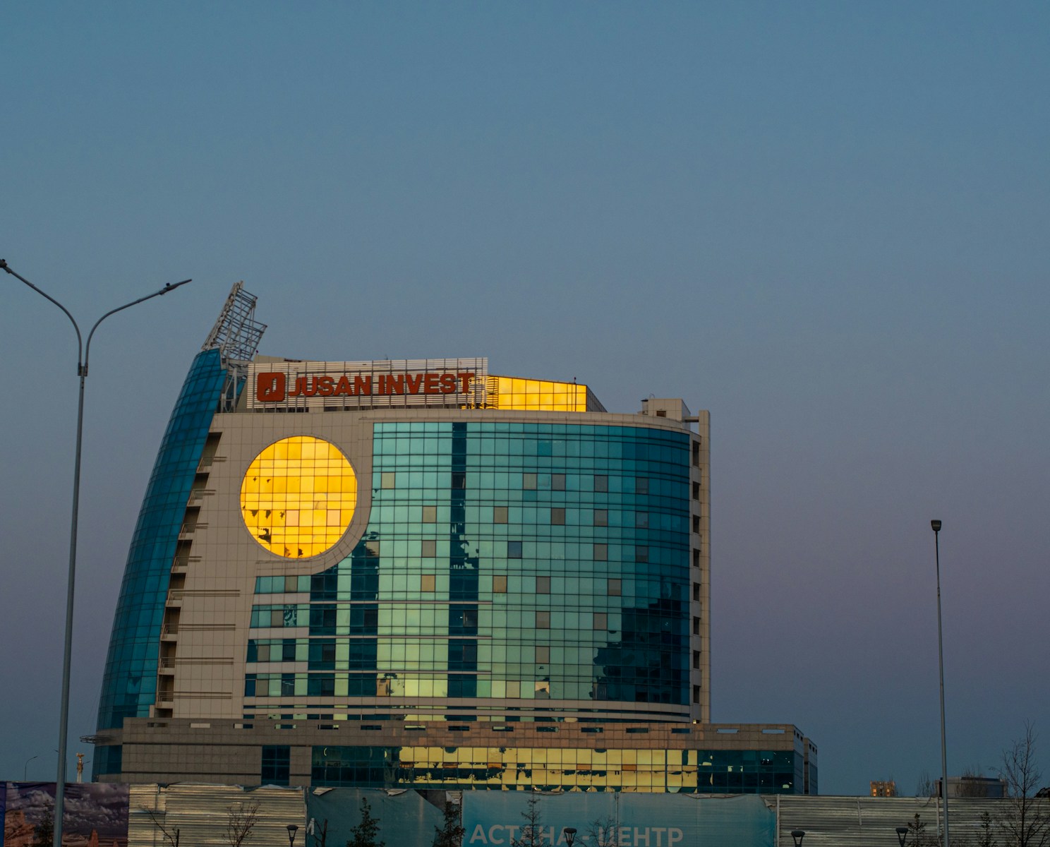 a tall building with a giant round sign on top of it