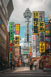 Tsutenkaku tower surrounded by vibrant neon signs in osaka.