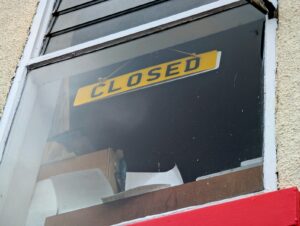 A yellow sign reads closed in a window.