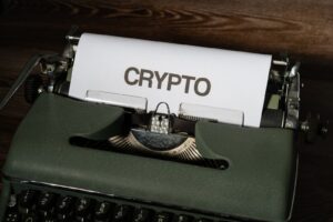 A classic typewriter displaying the word 'crypto' on paper, symbolizing digital currency's vintage connection.