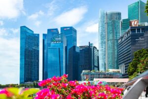 Vibrant skyscrapers in Singapore's Marina Bay with colorful flowers foreground.