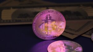 Bitcoin coin and us dollar bills
