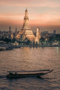 a boat in the water with a large building in the background