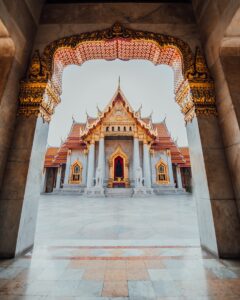 The Wat Benchamabophit temple framed by an ornate marble archway in Bangkok, Thailand