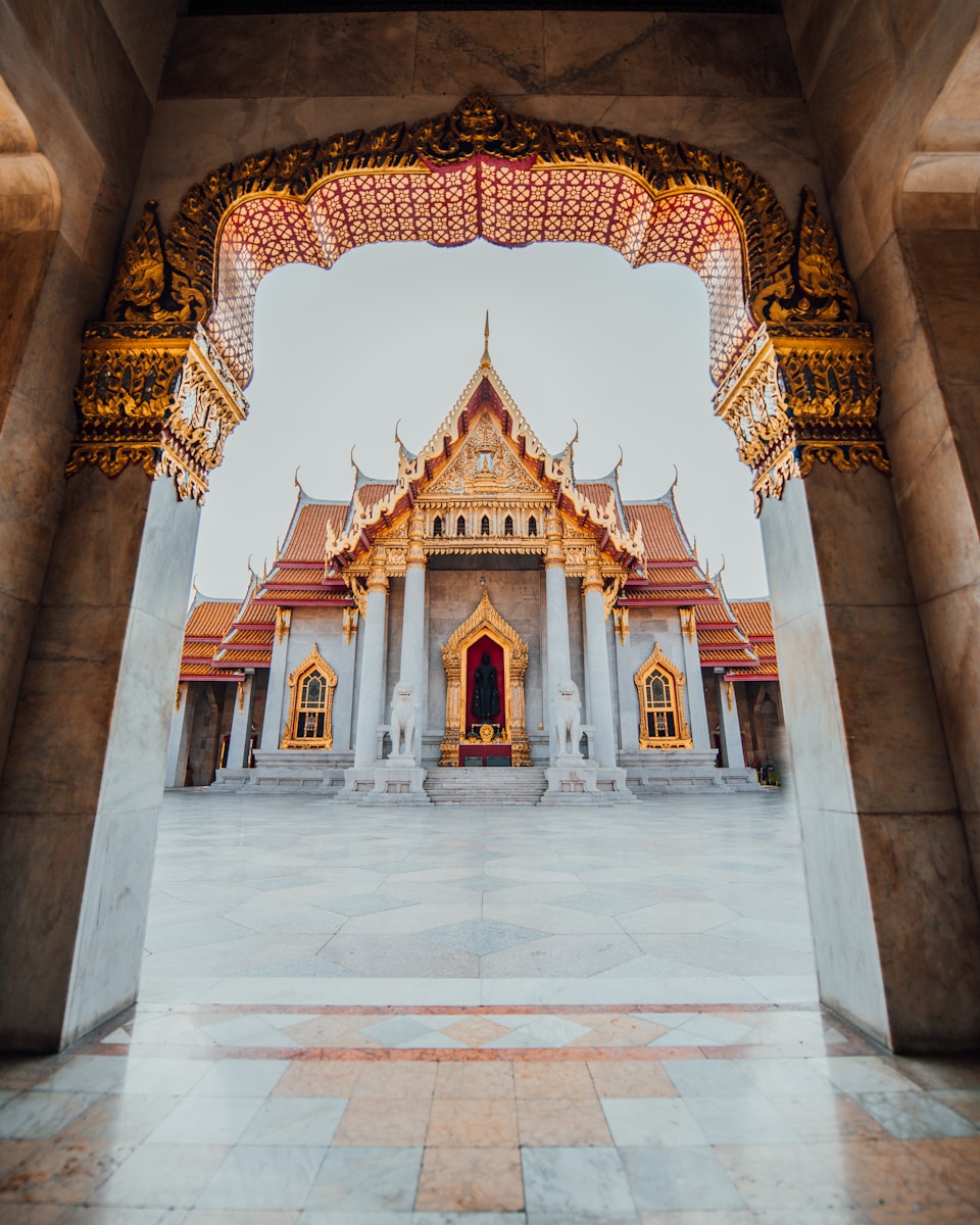 The Wat Benchamabophit temple framed by an ornate marble archway in Bangkok, Thailand