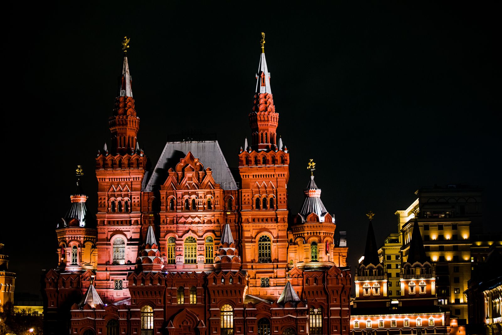 Illuminated State Historical Museum in Moscow during nighttime, showcasing architectural beauty.