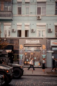 Busy city street with people passing by a Bitcoin exchange shop.