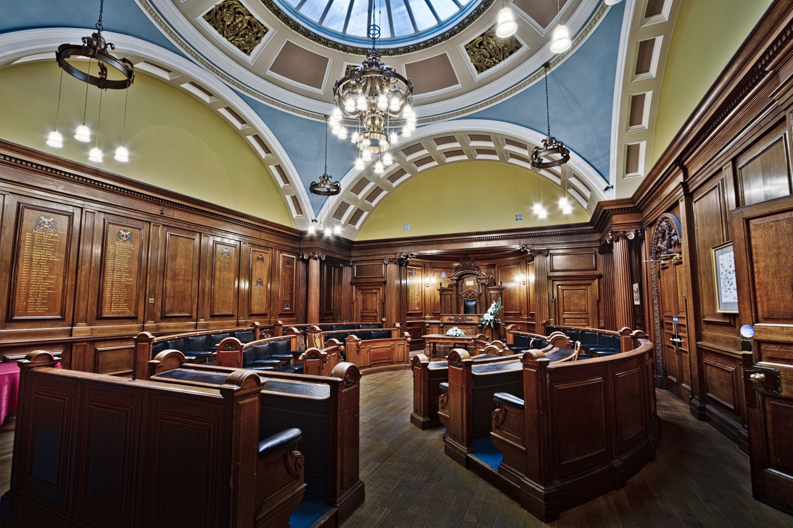 Victorian council chamber in Lancaster Town Hall with elegant wooden decor and skylight.