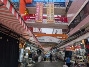 Explore the vibrant market scene in Seoul, South Korea, showcasing bustling shops and colorful signs.