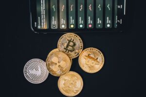 Close-up of various cryptocurrencies and a smartphone showing market trends.
