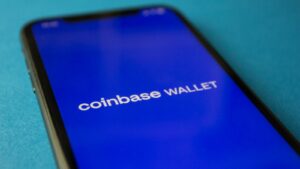 Close-up of a smartphone showing the Coinbase Wallet app interface for cryptocurrency transactions.