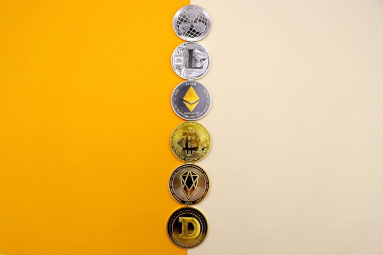 A row of cryptocurrency coins including Bitcoin, Ethereum, and Dogecoin on a vibrant yellow surface.