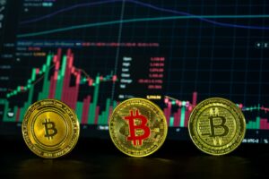Close-up of bitcoin coins in front of a financial market graph, symbolizing digital investment trends.