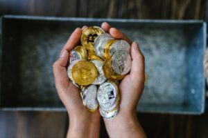 Close-up of hands holding gold and silver cryptocurrency coins, symbolizing digital investment.