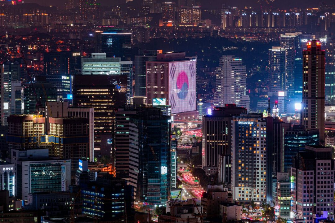 Vibrant night skyline of Seoul featuring illuminated skyscrapers and urban landscape.