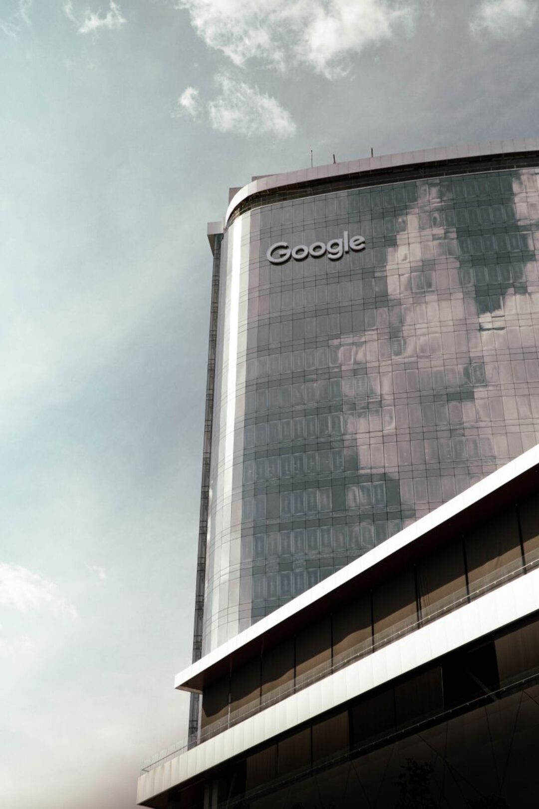 Low angle shot of a Google office skyscraper reflecting clouds in San Salvador, El Salvador.