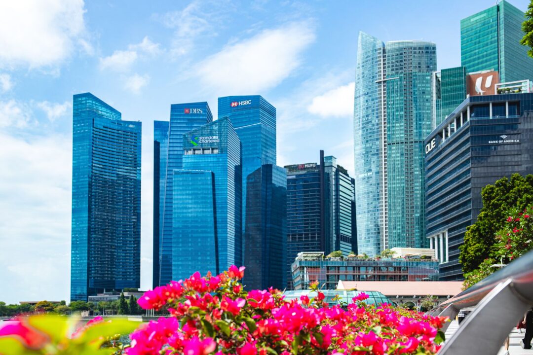 Vibrant skyscrapers in Singapore's Marina Bay with colorful flowers foreground.