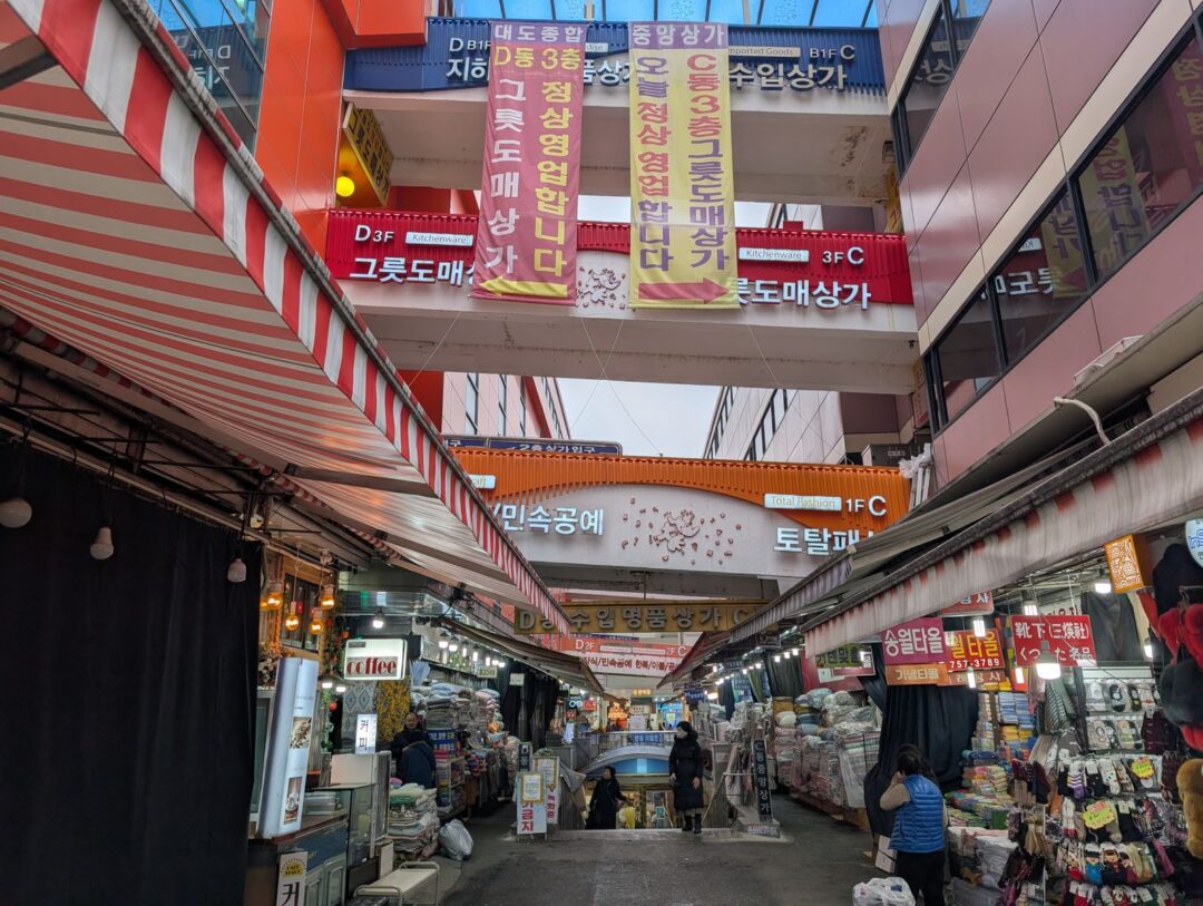 Explore the vibrant market scene in Seoul, South Korea, showcasing bustling shops and colorful signs.