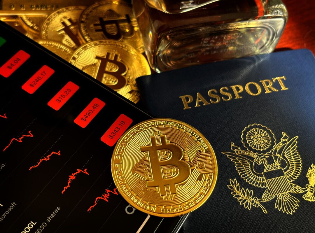 Bitcoin coin and passport placed next to a stock market graph, symbolizing global finance and investment trends.