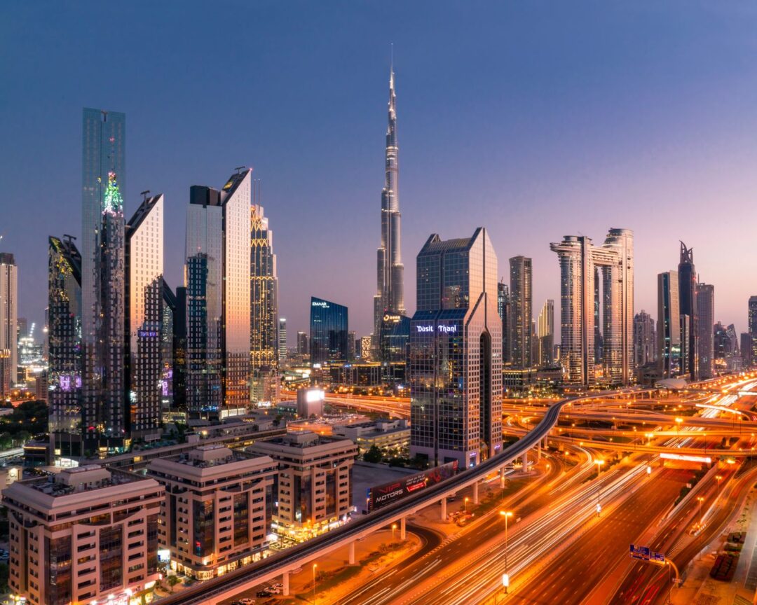 Stunning cityscape of Dubai with the Burj Khalifa and city lights illuminating the skyline at twilight.