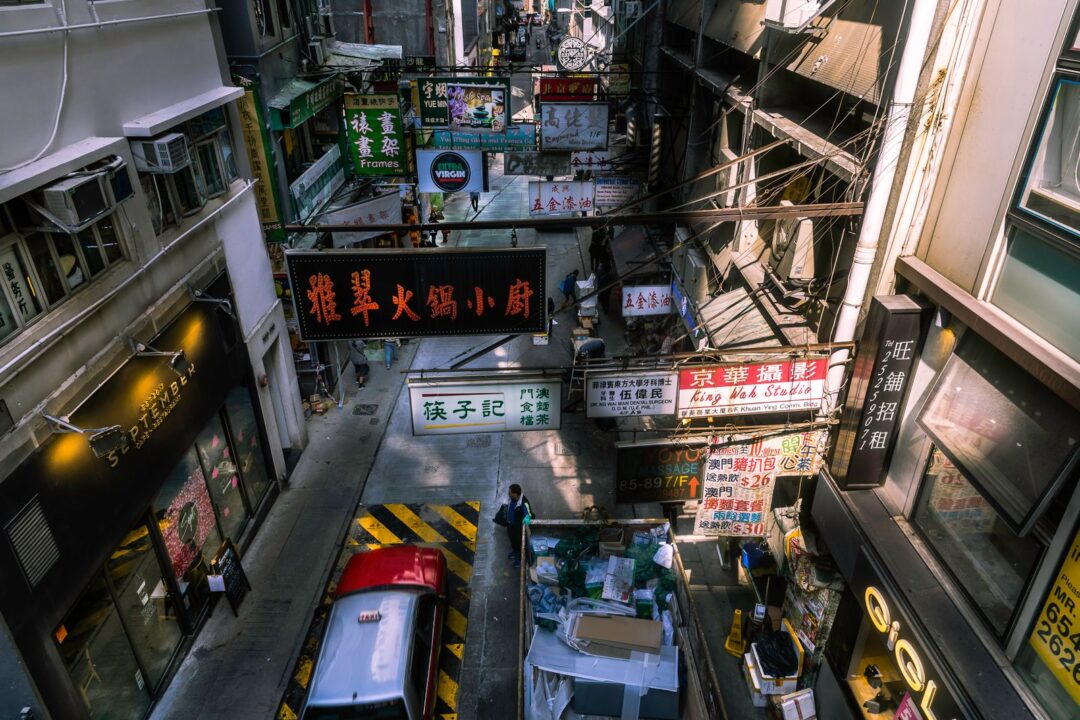 A vibrant view of a busy Hong Kong street market with colorful signage and bustling activity.