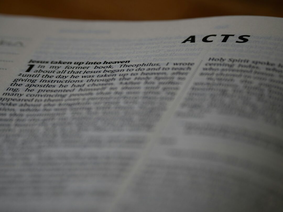 A close up of an open book with the words acts on it