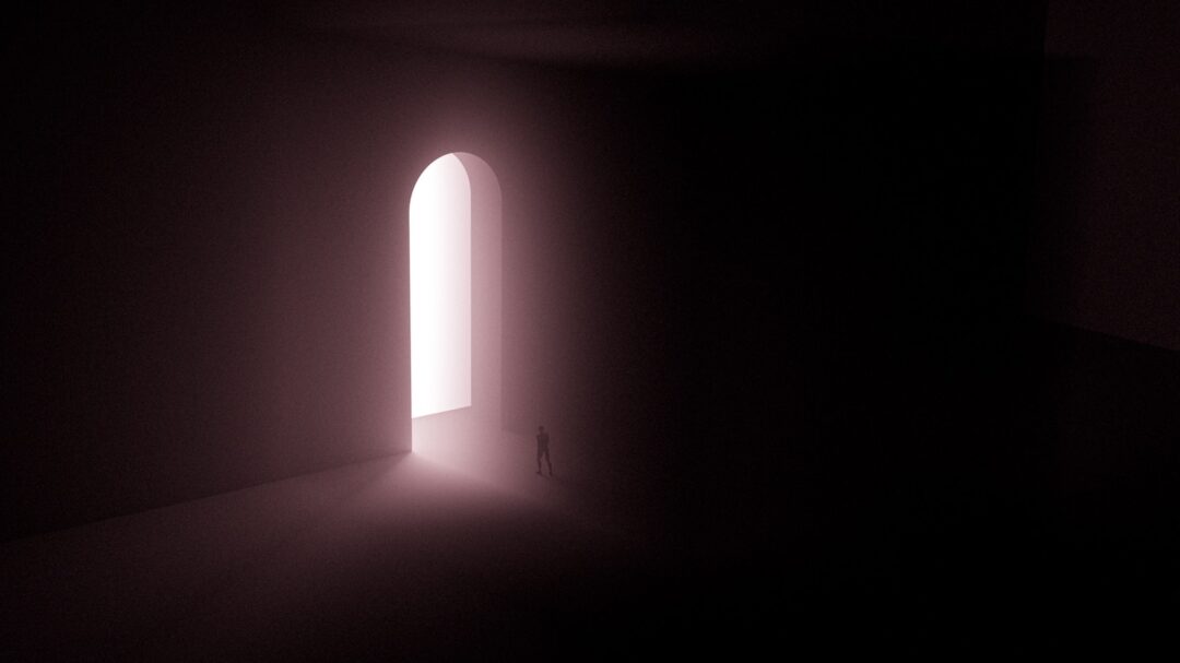 person in black jacket standing in the middle of the dark